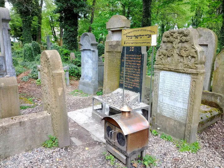 A tall memorial behind smaller headstones at New Jewish Cemetery, Kraków