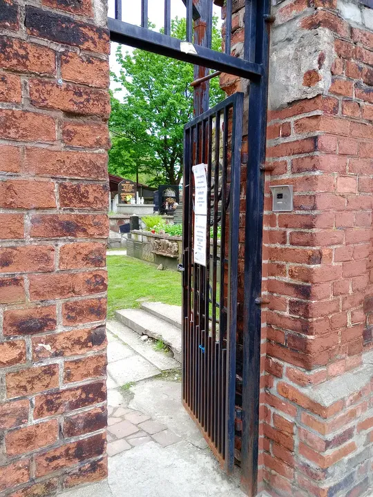 The entrance gate and older brick wall at New Jewish Cemetery, Kraków