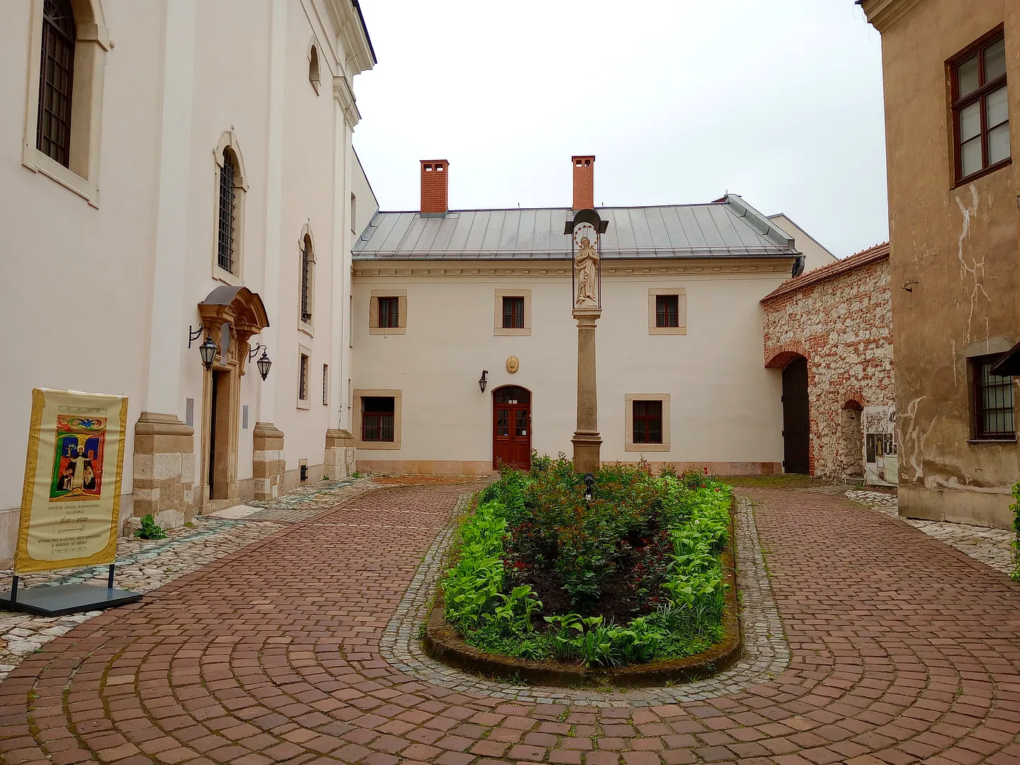 The church beyond a paved courtyard at Our Lady of the Snows Church, Kraków