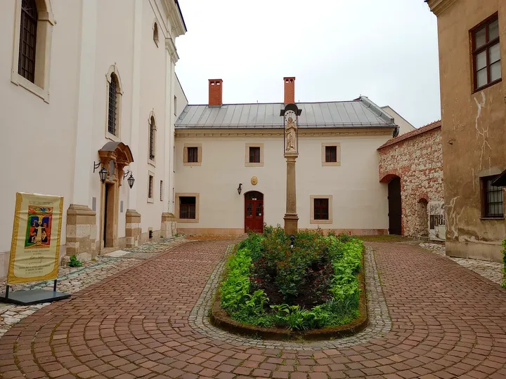 The church beyond a paved courtyard at Our Lady of the Snows Church, Kraków