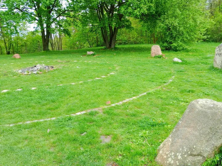 Standing stone and woodland backdrop at Peace Bells Garden, Kraków