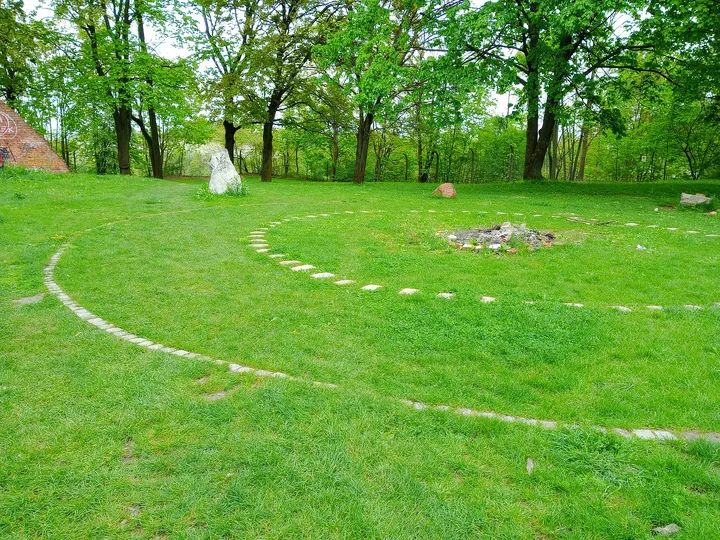 Tree-lined edge of the garden at Peace Bells Garden, Kraków