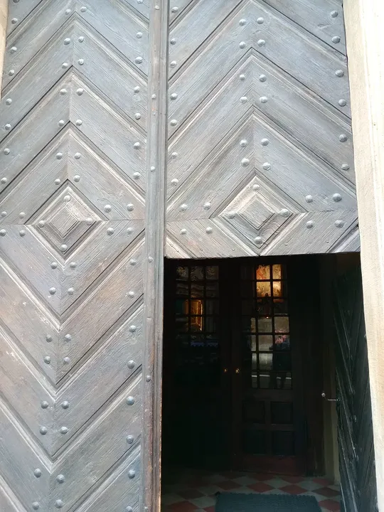 The entrance beneath carved stonework at Piarist Church of the Transfiguration