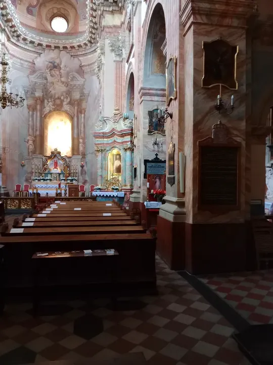 The central altar beneath painted arches at Piarist Church of the Transfiguration