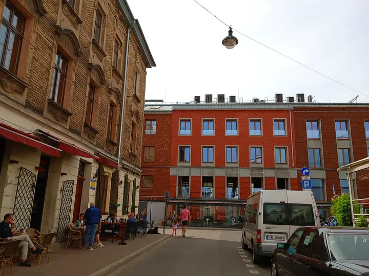 Lane opening towards the red building at Plac Izaaka street food square
