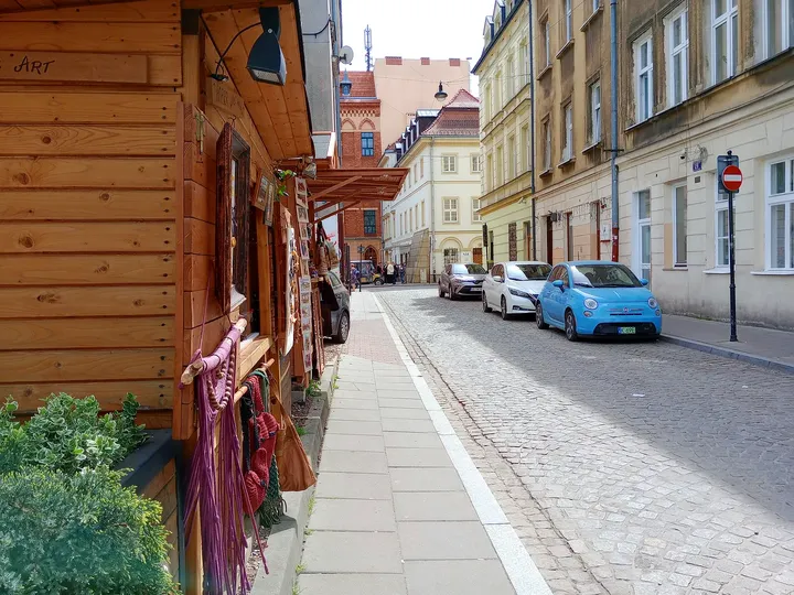 Neighbouring lane with outdoor tables at Plac Izaaka street food square