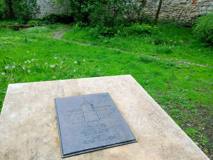 The stone marker beneath the trees at Planty beside Westerplatte Street