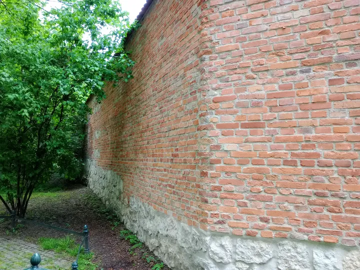 The long brick wall at the park edge at Planty: Florianka Garden