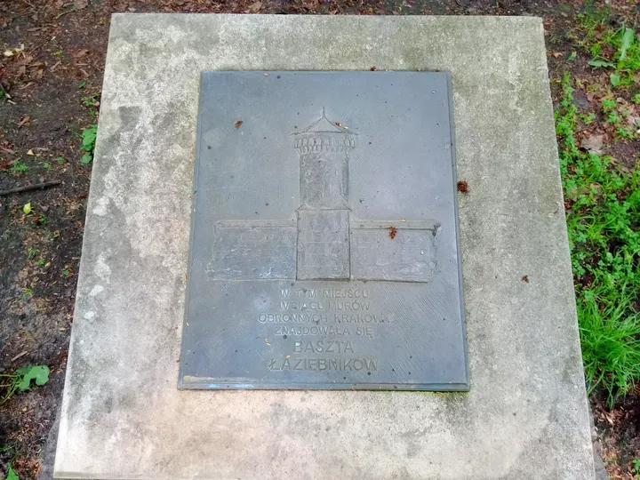 An inscribed plaque beside the path at Planty: Florianka Garden