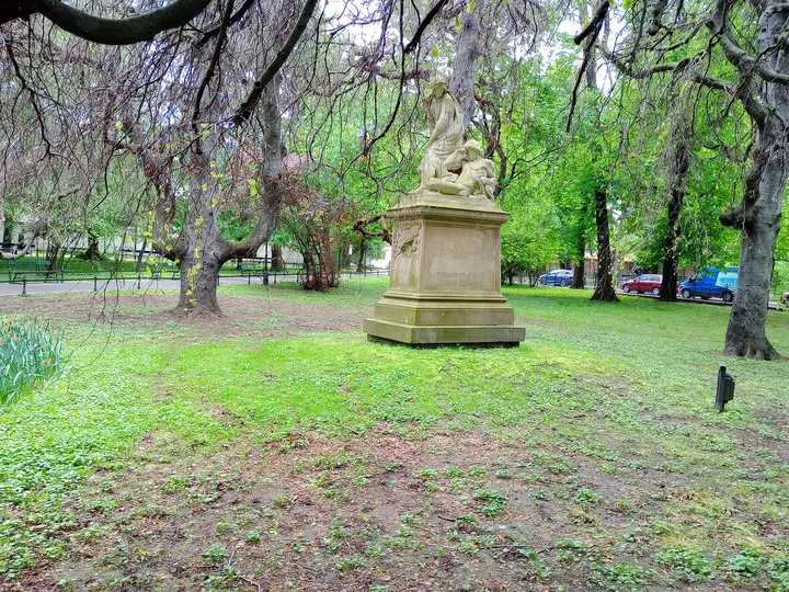 A monument among the trees at Planty: Wawel Garden