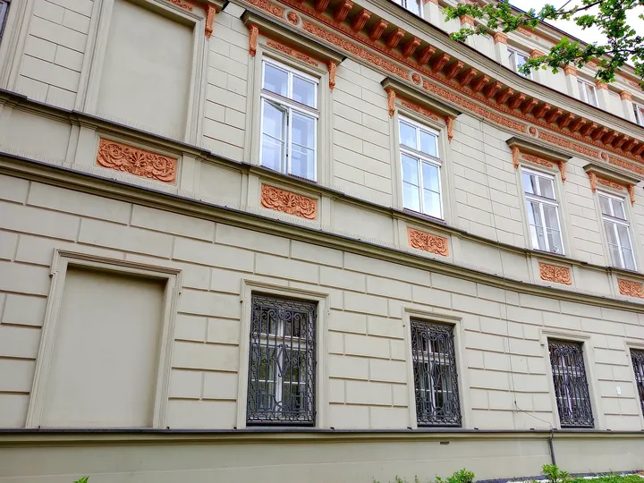 A pale façade beside the small garden at Poselska Street