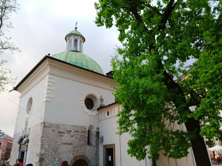 Green roof and pale walls beside the trees at Saint Adalbert’s Church, Kraków