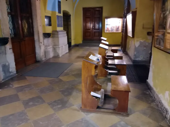 Corridor with stone floor and display cases at Saint Casimir’s Church, Kraków
