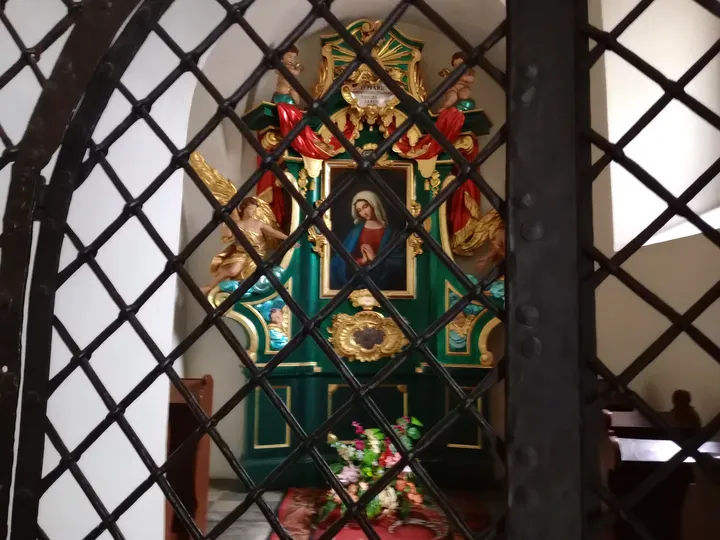 Stained glass behind an iron grille at Saint Mark’s Church, Kraków
