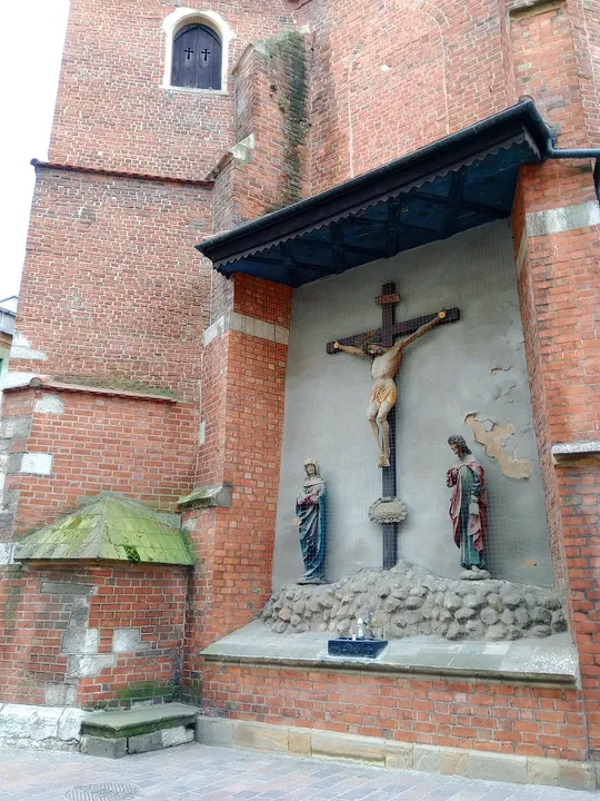 Sculptures beneath the brick church wall at Saint Mark’s Church, Kraków