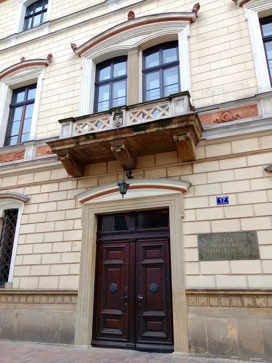 Carved balcony brackets above the doorway at Sławkowska Street