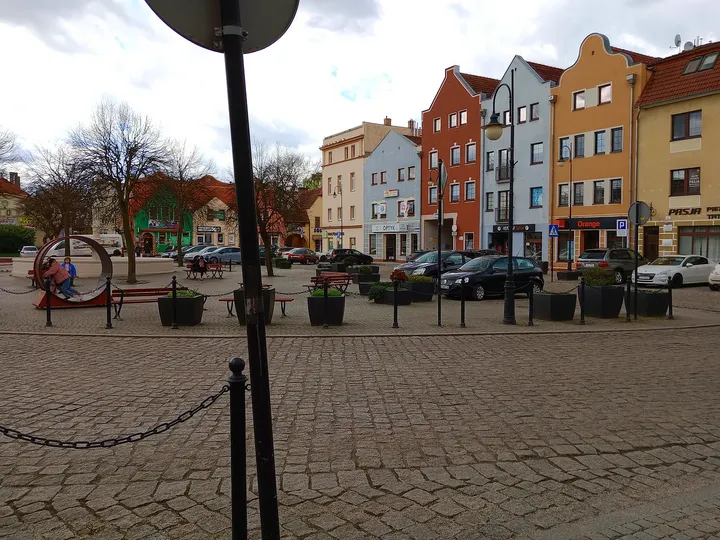 Lamp posts and trees along the paving at Słowiański Square, Żagań