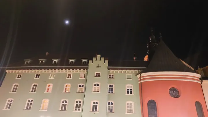 Townhouse façades lit after dark at Small Market Square, Kraków