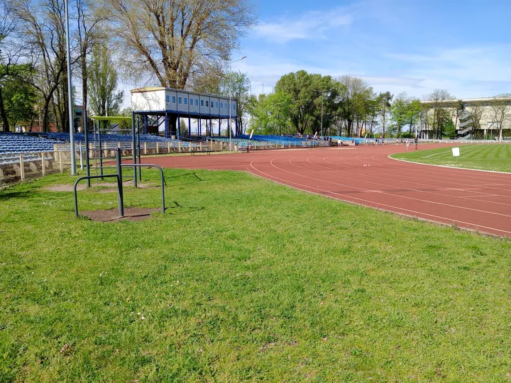 Equipment and track across the open space at Sulechowska stadium outdoor exercise ground
