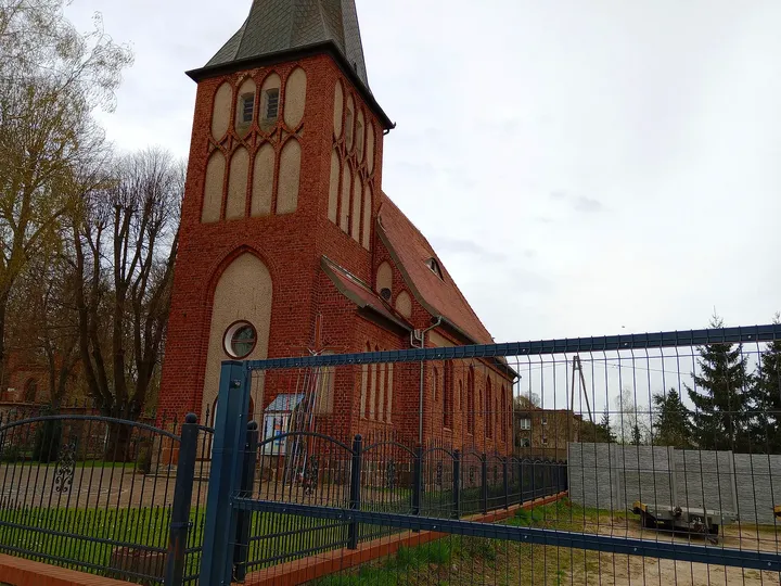 A brick church tower beside the road at Świebodzin town walk