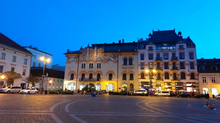 The lit townhouses across the square at Szczepański Square