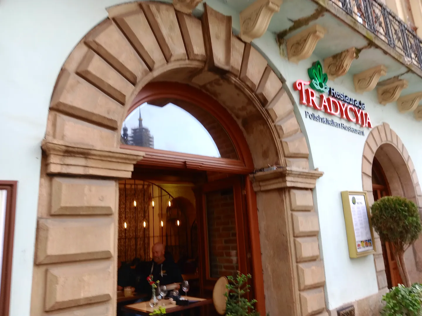 Arched restaurant entrance facing the square at Tradycyja