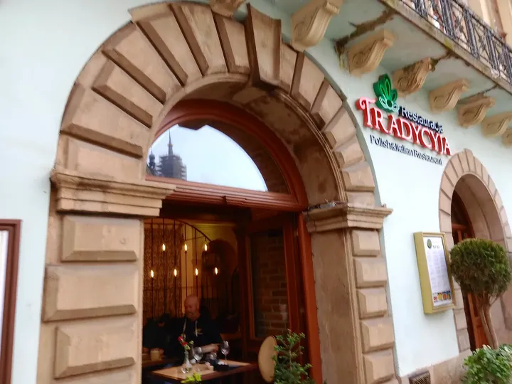 Arched restaurant entrance facing the square at Tradycyja