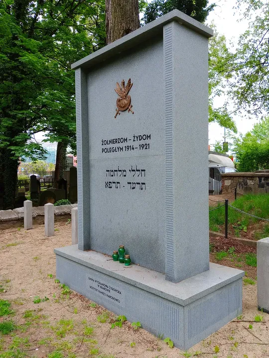 Polish and Hebrew inscriptions beneath the military emblem at War Cemetery No. 387, Kraków