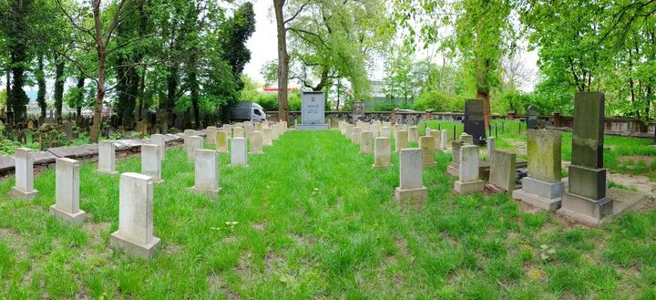 Grave markers below the spring canopy at War Cemetery No. 387, Kraków