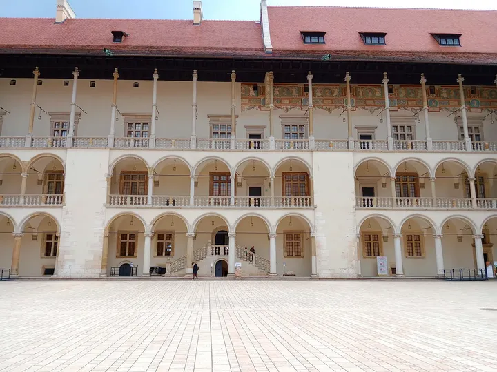 Rows of pale arches surround Wawel’s courtyard on Wawel Hill in Kraków