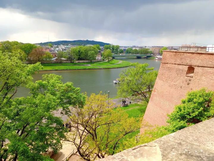 The Vistula seen past the edge of the walls, with the city beyond on Wawel Hill in Kraków