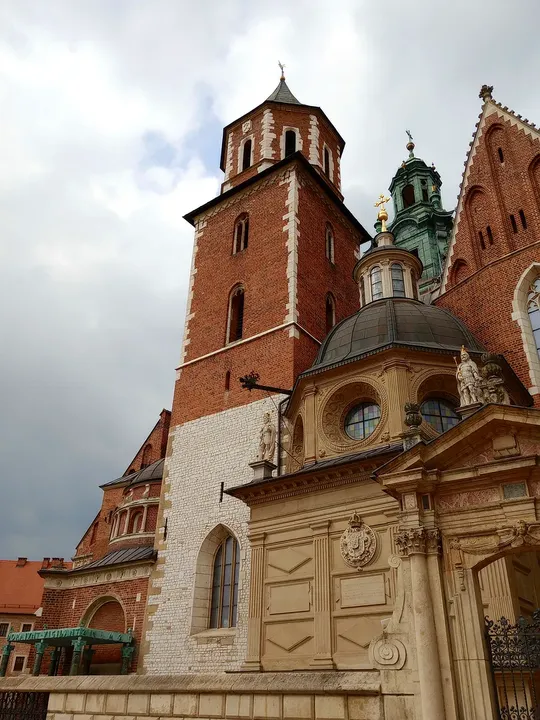 Wawel Cathedral’s towers and roof details rise above the hilltop walk on Wawel Hill in Kraków