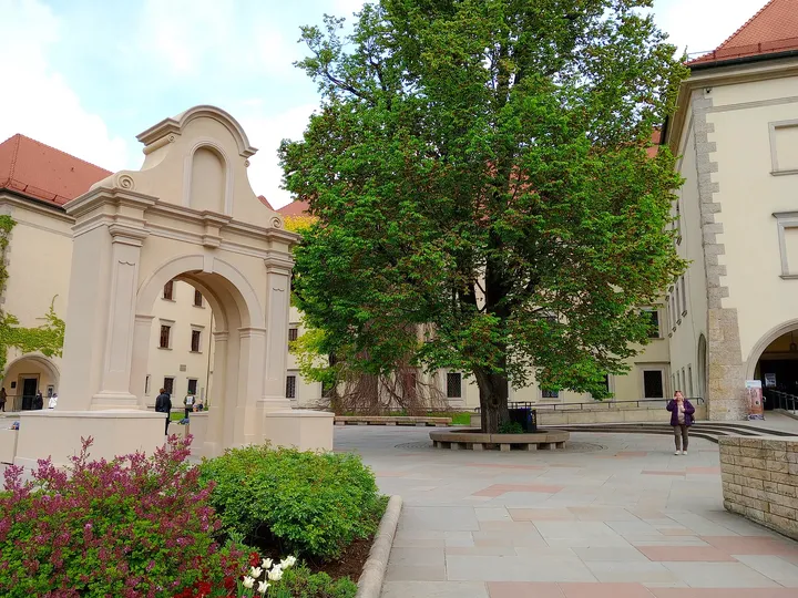 A pale façade and spring planting beside one of the paths across the grounds on Wawel Hill in Kraków