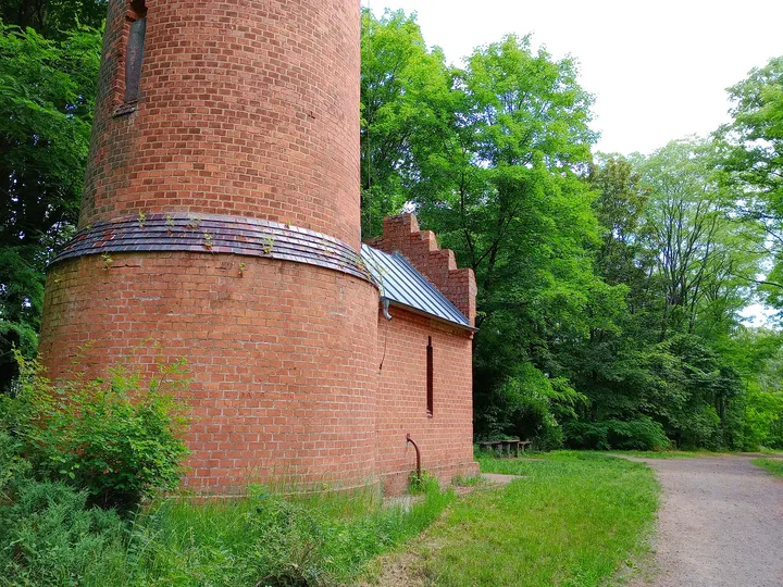 A plaque around the lower brickwork at Wilkanowo observation tower