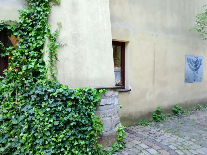 A plaque beside the courtyard wall at Wolf Popper Synagogue and Austeria