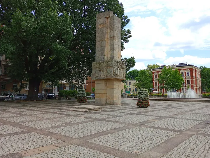 Sculpture and memorial base beneath the trees at World War II memorial, Zielona Góra