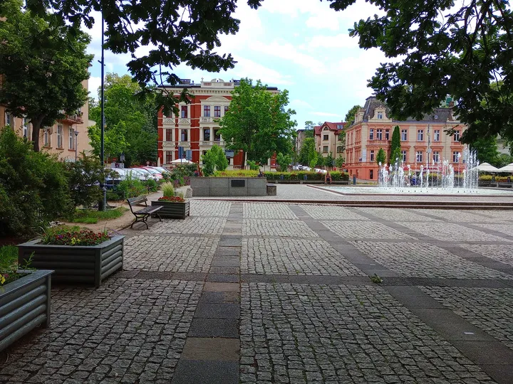 Wide paved space and town buildings at World War II memorial, Zielona Góra