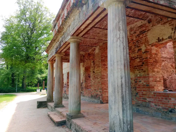 Stone columns and exposed brick meet along the sheltered edge of the palace in Zatonie Ducal Park