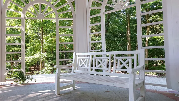 The white latticework frames the surrounding trees in this July 2022 photograph in Zatonie Ducal Park