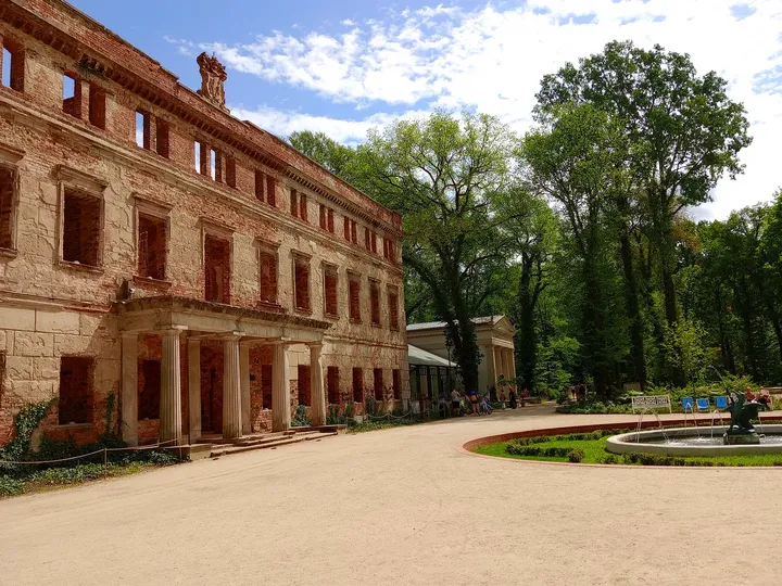 The long palace façade faces an open gravel path in Zatonie Ducal Park
