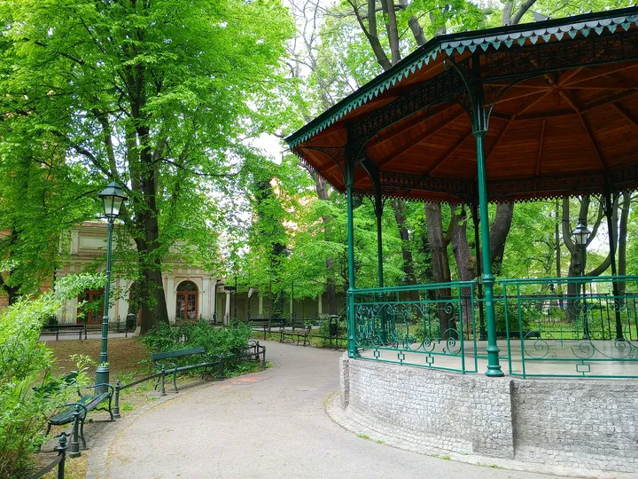 Roofed shelter among the trees at Zbigniew Wodecki Square