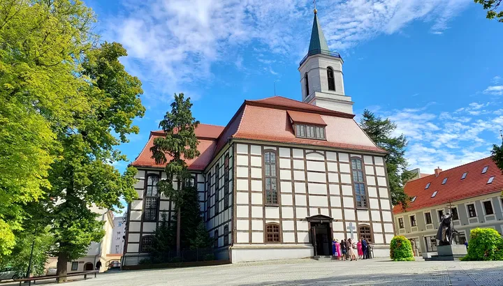Church frontage beyond the trees at Zielona Góra Old Market Square