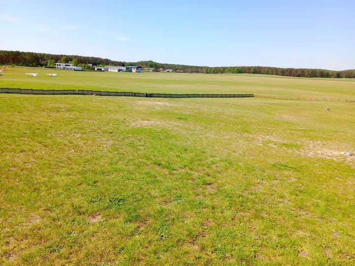 A broad view across the grass at Zielona Góra–Przylep airfield